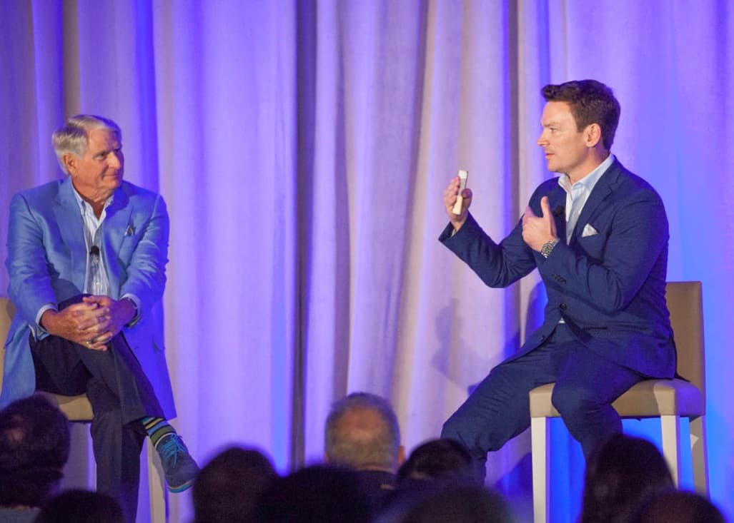 Dr. Michael Brumm presenting a porcelain restoration on stage during a live case demonstration at the Simplifying Complex CE seminar in Clearwater, Florida